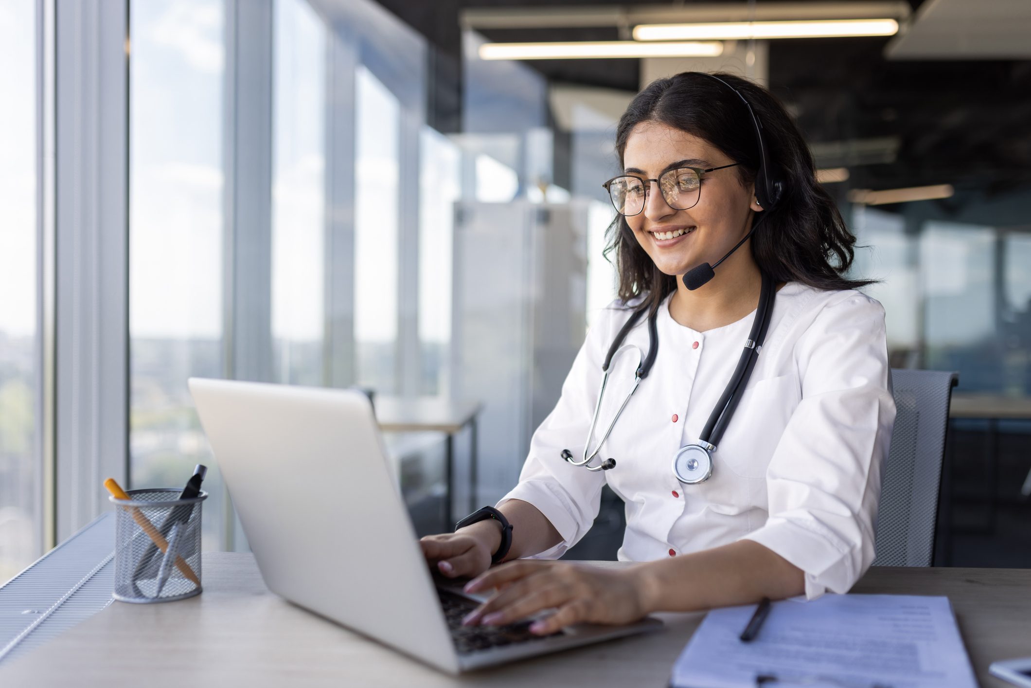 Doctor smiling while using a laptop.