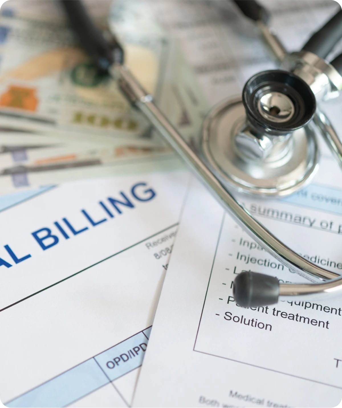 Medical bills and stethoscope on table.